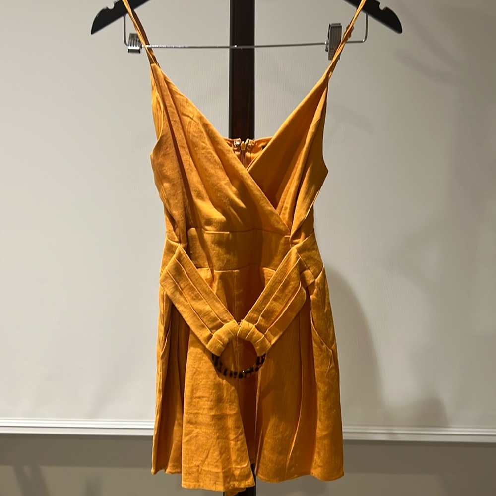 Orange romper with detailed waist belt.